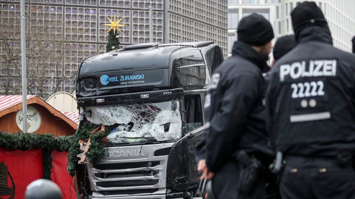 Polizisten stehen vor dem zerstörten LKW am Weihnachtsmarkt am Breitscheidplatz in Berlin (Quelle: dpa/Michael Kappeler)