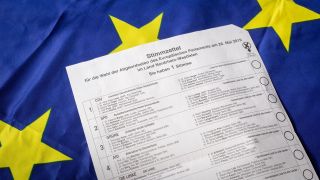Stimmzettel für die Europawahl 2019 vor einer Europaflagge (Bild: imago/Jürgen Schwarz)