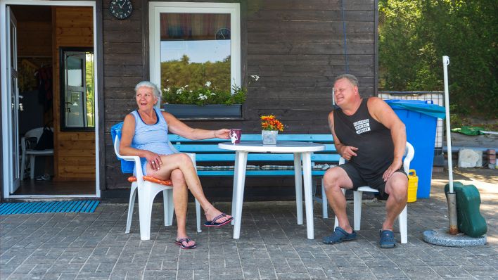 Elke Jenning und Mario Schmitz sitzen vor ihrem Bootsverleih in Strausberg, 20.07.2022 (Quelle: rbb/Czycykowski).