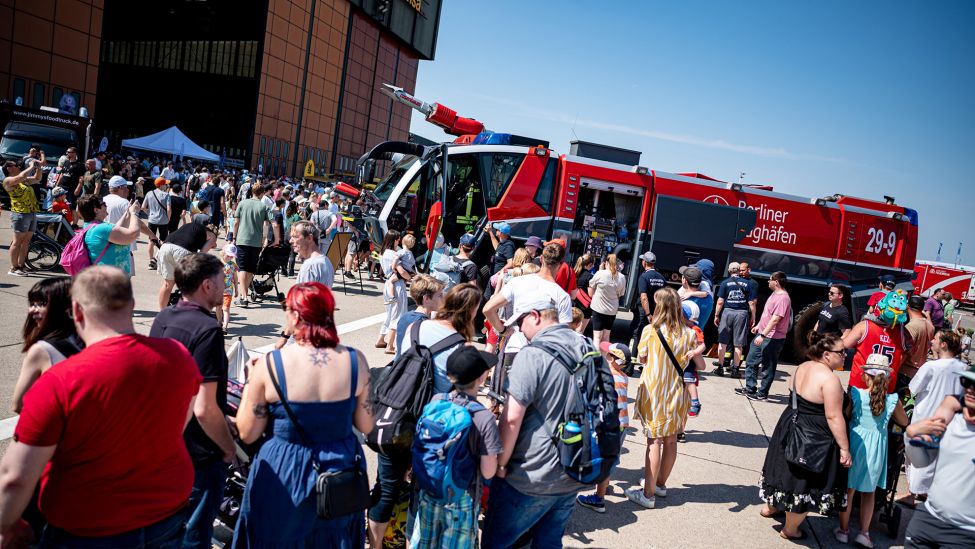 Besucher stehen auf dem Erlebnistag der Berliner Feuerwehr vor einem Löschfahrzeug der Flughafen Feuerwehr über das Gelände am ehemaligen Flughafen Tegel. (Quelle: dpa/F. Sommer)