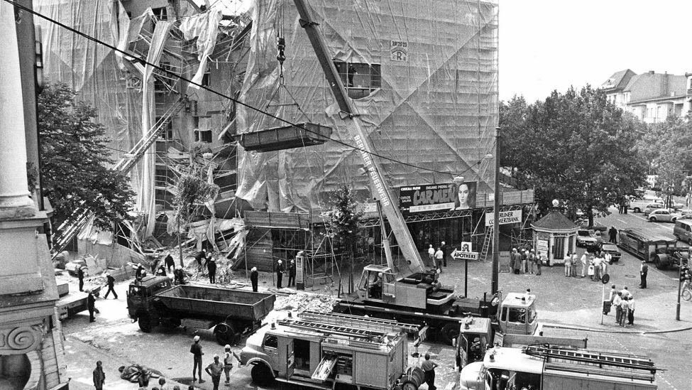 Die Berliner Feuerwehr sichert am 25.08.1983 das zerstörte Gebäude des "Maison de France" in Berlin ab. (Quelle: dpa/Giehr)