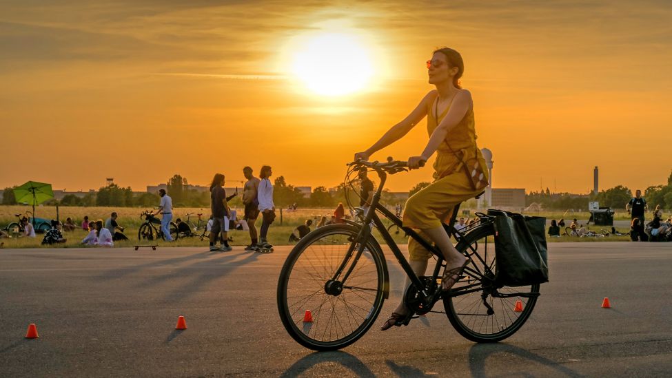 Eine Frau fährt am 09.06.2023 auf dem Tempelhofer Feld in Berlin Fahrrad. (Quelle: Picture Alliance/imageBROKER/Schoening)