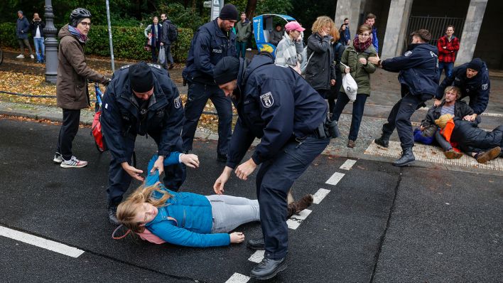 Polizisten tragen Klimaktivisten der letzten Generation von der Strasse des 17.Juni. (Quelle: dpa/Jochen Eckel)