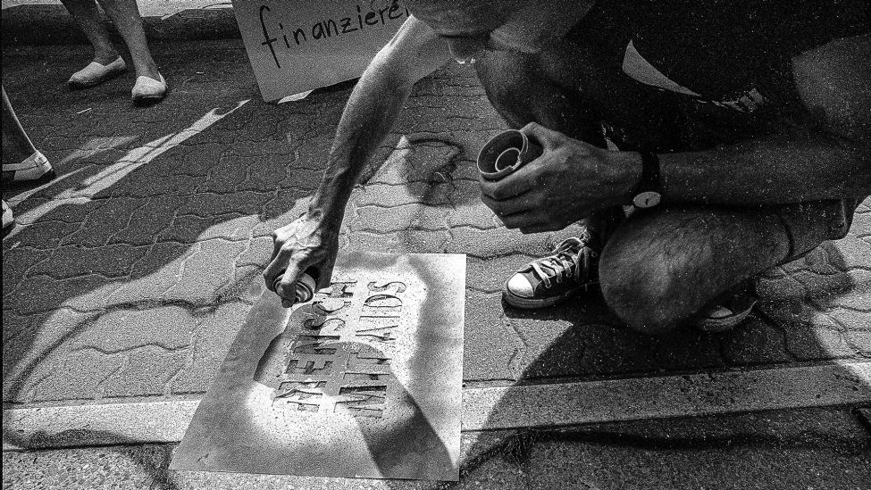 Ein Aktivist sprüht "Mensch mit Aids" am 21.04.1989 vor die Urania in West-Berlin. (Quelle: Imago Images/Michael Hughes)