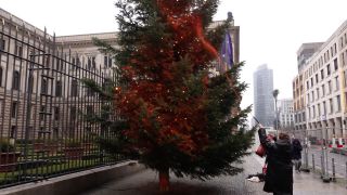 13.12.2023, Berlin: Ein Mitglied der Klimaschutzgruppe "Letzte Generation" besprüht einen Weihnachtsbaum vor dem Bundesrat mit orangener Farbe (Quelle: dpa/tnn/Sven Käuler)