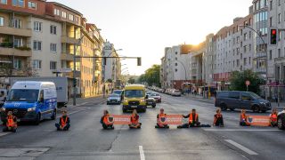 Archivbild: Mitglieder der Letzten Generation blockieren kurz nach Sonnenaufgang die Kreuzung Spandauer Damm Ecke Sophie-Charlotten-Straße. (Quelle: dpa/Müller)