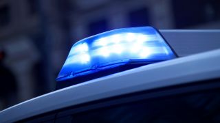 Symbolbild: Ein Polizeifahrzeug fährt mit Blaulicht zu einem Einsatz.(Quelle:picture alliance/M.Koch)