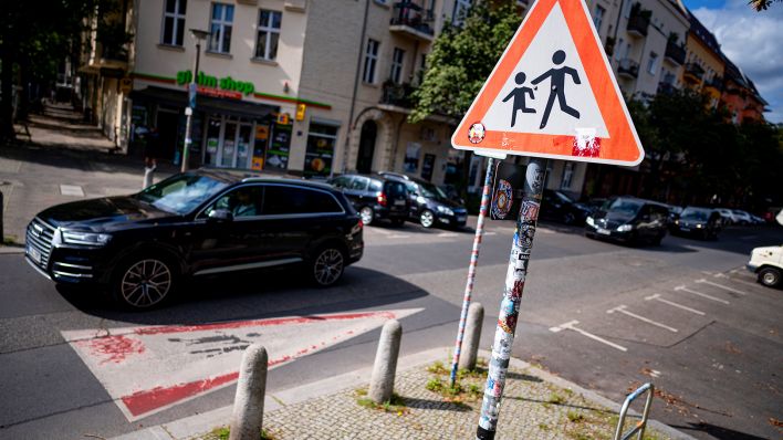 Symbolbild: Ein SUV fährt an einem Hinweisschild für Schüler in der Prenzlauer Allee vorbei. (Quelle: dpa/Fabian Sommer)
