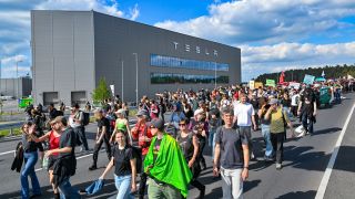 Brandenburg, Grünheide: Teilnehmer einer Protestveranstaltung gehen zum Werk von Tesla. Nach teils heftigen Auseinandersetzungen am 10.05.2024 am Tesla-Werksgelände in Grünheide bei Berlin stellt laufen derzeit neue Proteste gegen das US-Unternehmen.