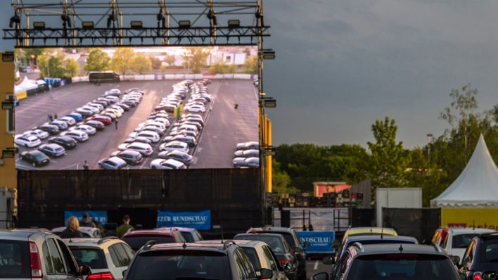 Autokino in Cottbus große Leinwand mit Autos und die Autos vor der Leinwand