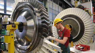 Siemens-Mitarbeiter arbeitet in Berlin an einer Gasturbine (Bild: Rainer Jensen/dpa)