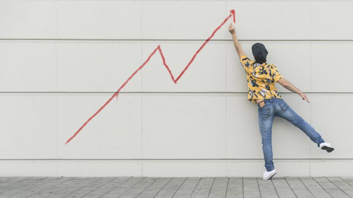 Digital composite of young man drawing a line graph at a wall model released Symbolfoto property released