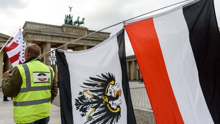 Ein Reichsbürger posiert vor dem Brandenburger Tor in Berlin. (Bild: imago/snapshot)
