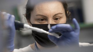 Eine Laborantin bereitet eine Probe mit extrahierter RNA fuer PCR-Tests vor, bei denen Mutationen des Coronavirus erkannt werden sollen