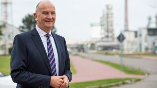 Archivbild: Dietmar Woidke (SPD), Ministerpräsident von Brandenburg, lächelt bei einem Besuch der PCK-Raffinerie im Jahr 2020.