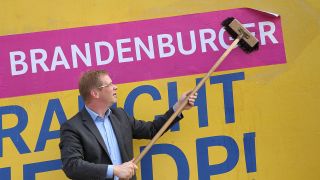 FDP-Spitzenkandidat Andreas Büttner vor einem Wahlplakat der Brandenburger FDP. (Bild: imago)