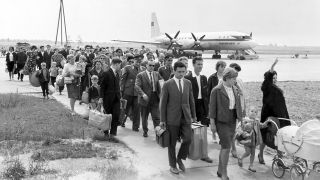 Eine Gruppe Urlauber aus der DDR nach dem Heimflug aus der Sowjetunion am 16.06.1964 auf dem Flughafen Berlin-Schönefeld (DDR). (Bild: dpa-Report)