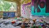 Ein Raum mit besonders viel Müll und leeren Flasche auf dem Boden, an der Wand Graffiti (Quelle: Götz Gringmuth-Dallmer/rbb)
