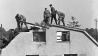 Arbeiter stehen auf dem Dach eines Hauses im Norden Berlins und führen Abrissarbeiten durch (Quelle: dpa)