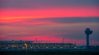 Blick auf den beleuchteten Terminal des Flughafens Berlin Brandenburg Airport Willy Brandt und den Tower am frühen Morgen (Quelle: dpa)