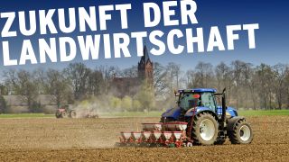 Traktor auf Feld beim Mais drillen, im Hintergrung Backsteinkiche (Quelle: IMAGO/Rainer Weisflog)