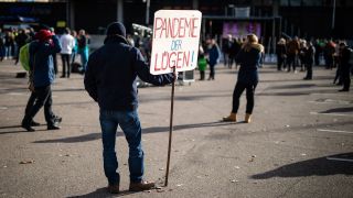 "„Pandemie der Lügen!"“ steht auf dem Schild eines Mannes, der an einer Demonstration gegen die Corona-Politik der Bundesregierung teilnimmt. Bild: Christoph Schmidt/dpa