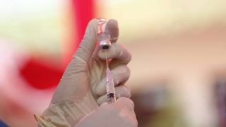 Impfspritze wird geladen (Quelle: imago/Pacific Press Agenc)