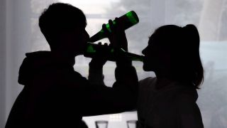 Schatten zweier Jugendlicher mit Bierflaschen am Mund (Bild: imago images/epd)