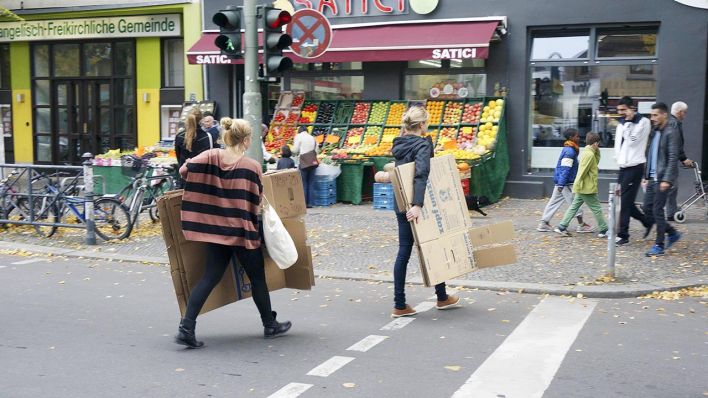 Zwei Frauen tragen mit Umzugskartons in Berlin-Kreuzberg. (Quelle: Imago/Steinach)