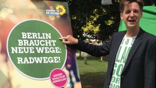 Daniel Wesener, eine der vier Spitzenkandidaten der Grünen für die Berliner Abgeordnetenhauswahl, vor einem Wahlplakat. (Quelle: rbb / Nina Amin)