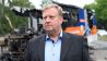 Der CDU-Politiker Thilo-Harry Wollenschlaeger steht vor seinem abgebrannten Wahlkampfbus (Quelle: Rainer Jensen/dpa)