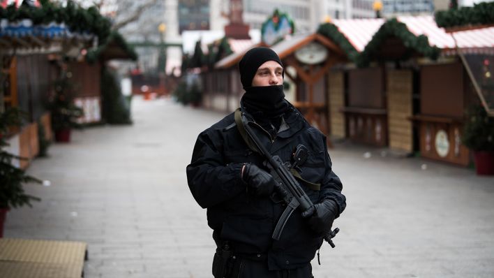Ein mit Maschinenpistole bewaffneter Polizist steht am 21.12.2016 am Anschlagsort auf dem Weihnachtsmarkt am Breitscheidplatz in Berlin. (Quelle: dpa/Bernd von Jutrczenka)