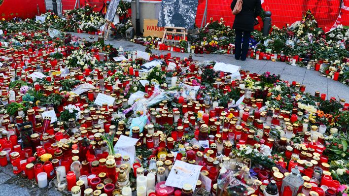 Eine Frau bleibt am 05.01.2017 in Berlin vor Kerzen und Blumen stehen, um der Opfer des Anschlags auf den Weihnachtsmarkt am Breitscheidplatz zu gedenken (Quelle: dpa/Maurizio Gambarini)