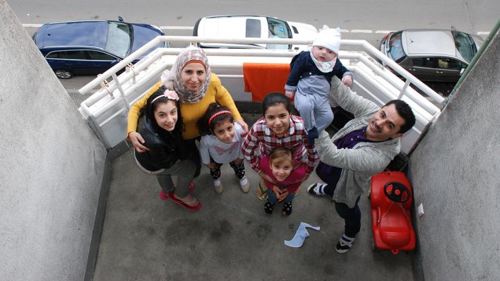 Familie Ismail aus Aleppo steht am 11.3.2017 nach ihrem Umzug aus der Notunterkunft gemeinsam mit Maya aus Berlin, der Freundin der Tochter Rama, auf dem Balkon ihrer neuen Wohnung in Berlin (Quelle: rbb/Maria Kindling)
