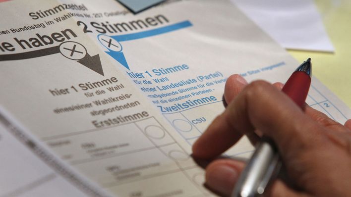 Eine Hand hält einen Kugelschreiber über Stimmzettel für die Bundestagswahl 2013 (Quelle: dpa/Karl-Josef Hildenbrand)