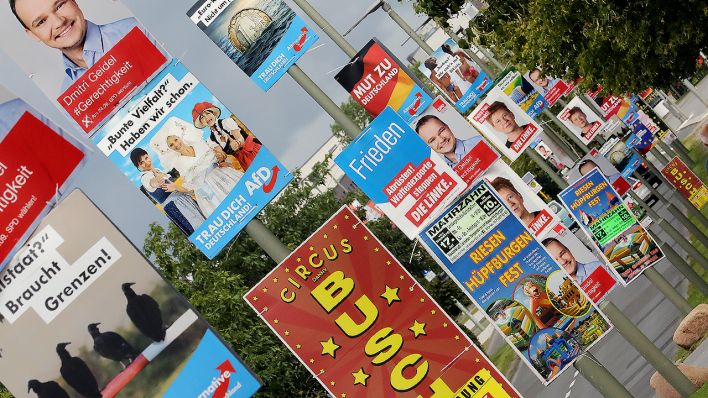 Neben herkömmlicher kommerzieller Werbung benutzen politische Parteien am 22.08.2017 Straßenlaternen im Berliner Bezirk Marzahn um ihre Wahlplakate für die Bundestagswahl zu platzieren. (Quelle: dpa/Wolfgang Krumm)