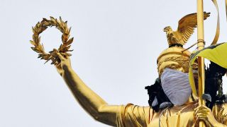 Aktivisten der Umweltschutzorganisation "Greenpeace" haben am 31.01.2017 in Berlin eine Atemschutzmaske der Statue auf der Siegessäule übergezogen. (Quelle: dpa/Paul Zinken)