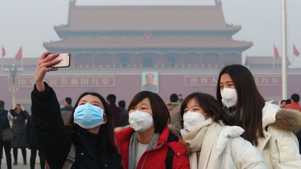 Touristen mit Atemschutzmasken machen in Peking ein Selfie (Quelle: Imaginechina/Wang Xin)