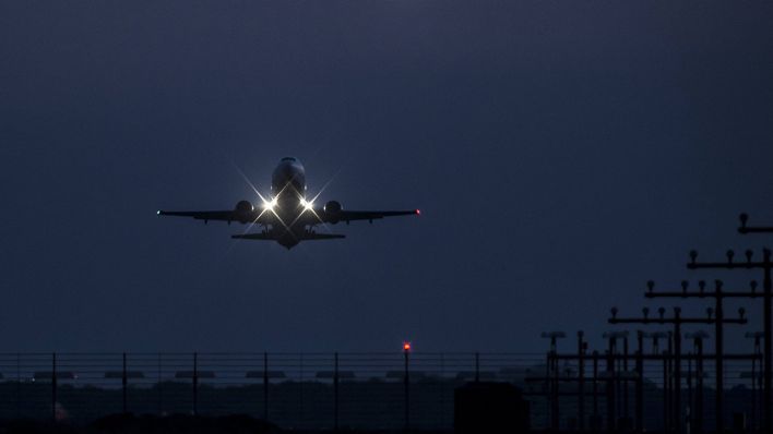 Ein Flugzeug startet und eines landet zur blauen Stunde vom Flughafen Tegel in Berlin (Quelle: imago/Florian Gaertner)