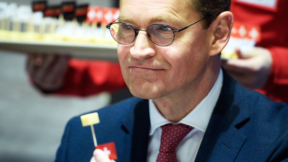 Der Regierende Bürgermeister von Berlin, Michael Müller (SPD), probiert am 19.01.2018 auf der 83. Internationalen Grünen Woche in Berlin am Stand der Schweiz einen Käsehappen (Quelle: dpa/ Gregor Fischer)