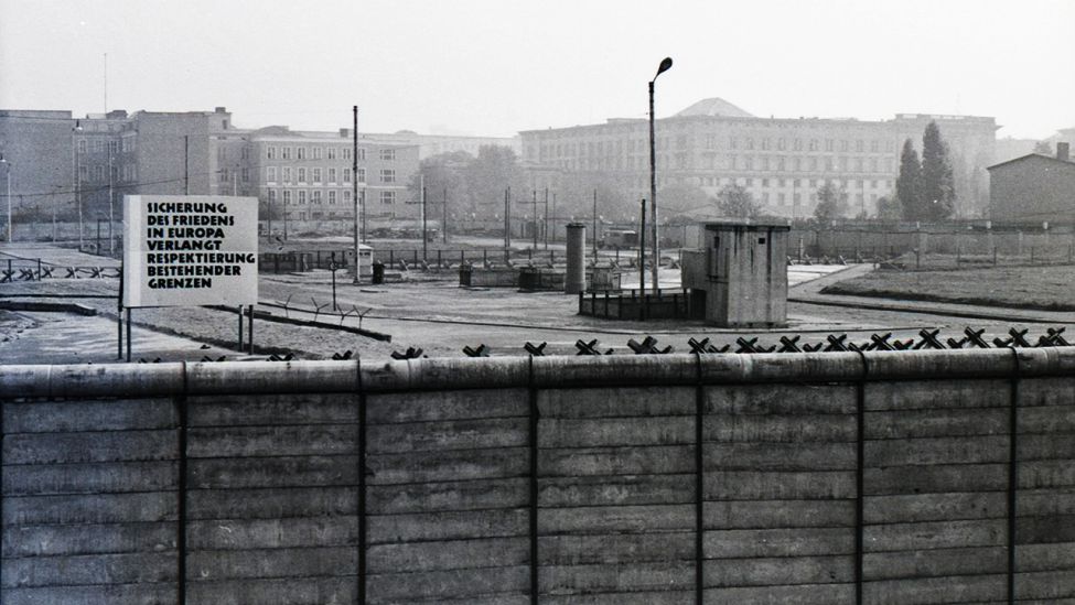 Blick über die Mauer auf ein Propagandaschild im Jahr 1971 (Quelle: Stiftung Berliner Mauer/Albrecht Roos)