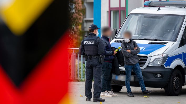Archivbild: Ein Polizist und zwei angehaltene Männer stehen während einer Grenzkontrolle auf der Grenzbrücke zwischen Deutschland und Polen an einem Polizeifahrzeug. (Quelle: dpa/M. Skolimowska)