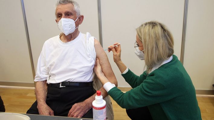 Symbolbild: Ein Senior lässt sich bei einer mobilen Impfaktion impfen. (Quelle: imago images/R. Poller)