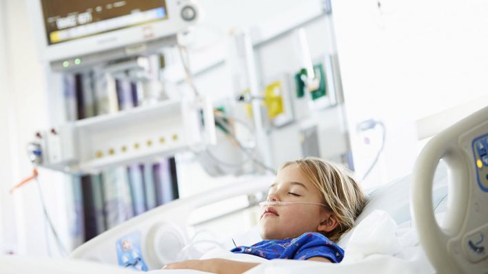 Symbolbild: Ein krankes Mädchen liegt in einem Krankenhaus auf einem Krankenhausbett. (Quelle: imago images/monkeybusiness)