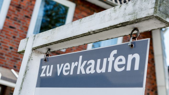 Vor einem Haus hängt ein Schild: "Zu verkaufen". Quelle: dpa/Markus Scholz