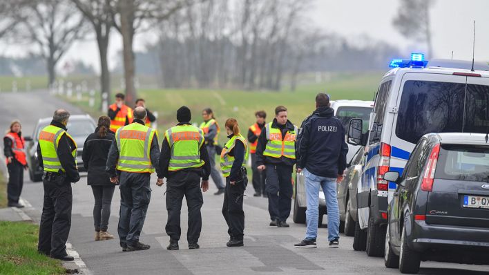 Symbolbild: Polizeibeamte sind während der Suche nach der vermissten Rebecca aus Berlin an einer Landstraße nahe dem Scharmützelsee im Landkreis Oder-Spree zu sehen. (Quelle: dpa/Pleul)
