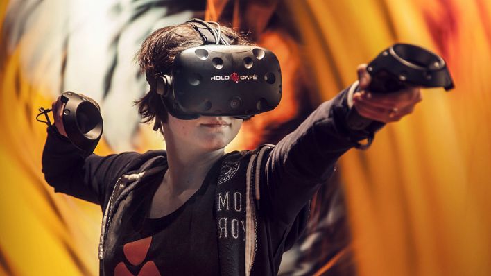 Eine Frau spielt während einer Gaming-Ausstellung mit einer VR-Brille (Bild: imago)