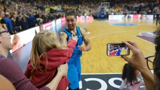 Alba Berlins Point Guard Peyton Siva freut sich nach dem Sieg im zweiten Eurocup-Finalspiel gegen Valencia Basket am 12.04.19 in der Mercedes-Benz-Arena Berlin über die Glückwünsche eines kleinen Mädchens (Quelle: rbb|24 / Schneider).