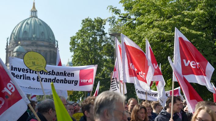 Streikende halten Fahnen und Schilder bei einem Warnstreik von Bankangestellten in Berlin und Brandenburg