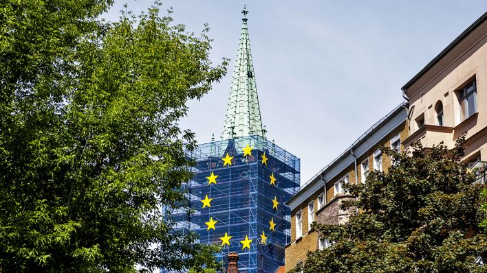 Symbolbild: Der zur Sanierung eingerüstete Kirchturm der Gethsemanekirche in Berlin-Prenzlauer Berg wurde zu einer übergroßen Europaflagge umgestaltet (Quelle: Imago/ Seeliger)